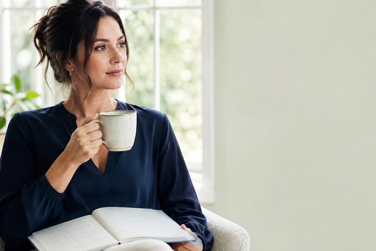 Vrouw zit rustig thuis met een kop thee, themabeeld bij herstel van gordelroos